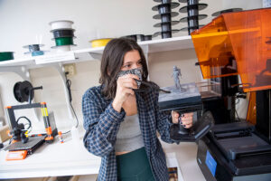 a Luther student removing a model from a 3D printer