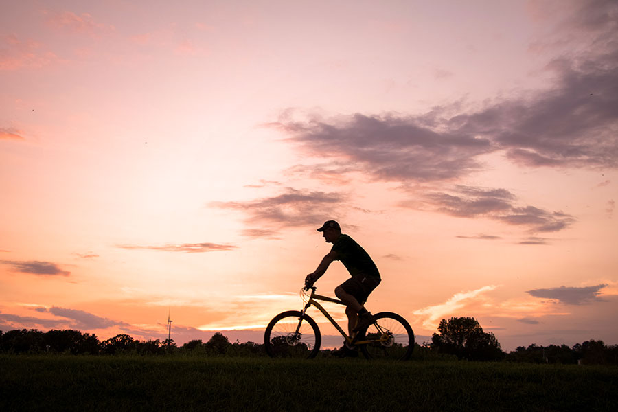 a community member biking at sunset in Decorah