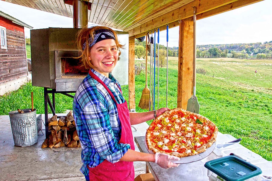 a woman holding a pizza