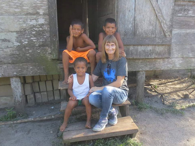 Photo of Nola Nackrud sitting on house steps with three children