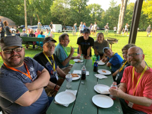 Photo of a group of people at a picnic table in the summer