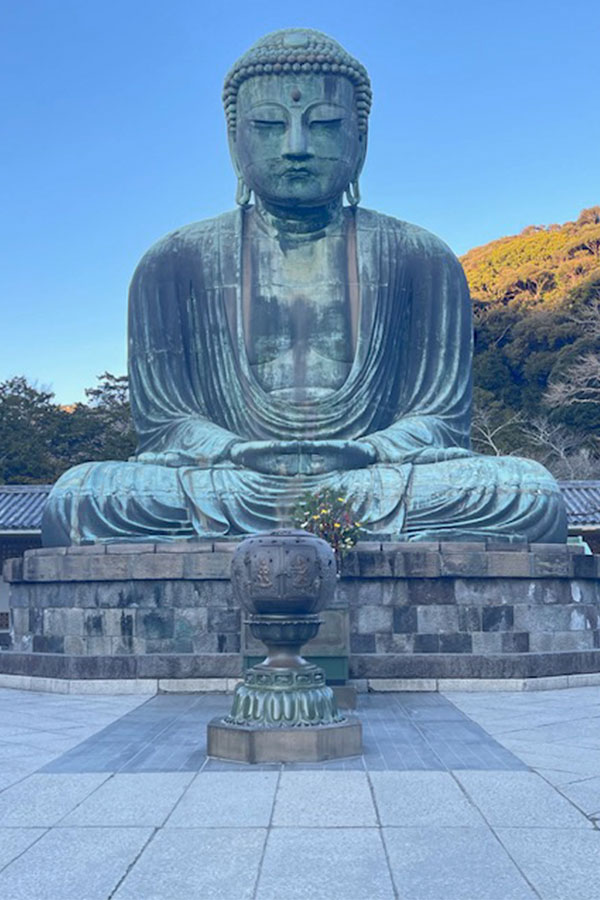 A giant statue of a patina-ed Buddha sitting with crossed legs