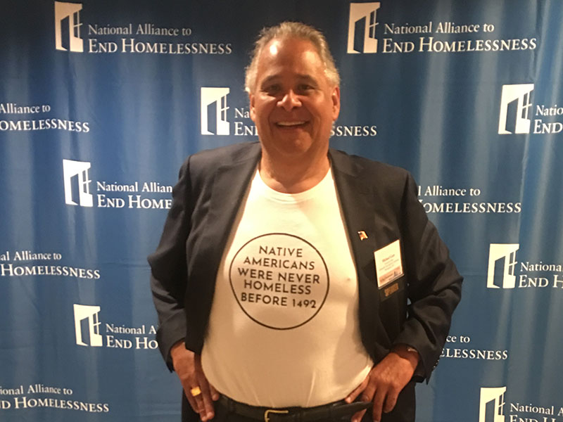 A man wearing a T-shirt that reads “Native Americans were never homeless before 1492”