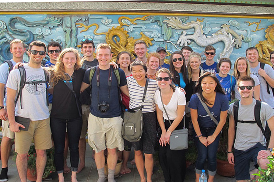 A group of students posing at a Buddhist temple in Cambodia.