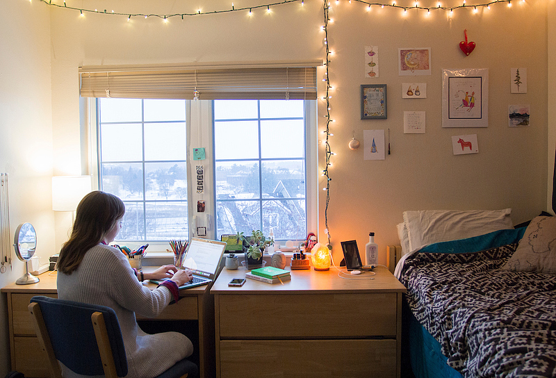 student studies in dorm room with snow outside