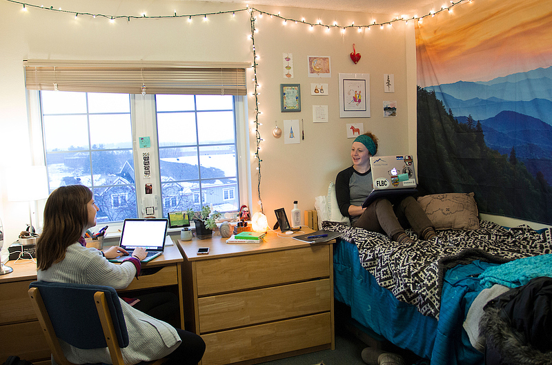 students with MacBook's carry conversation in dorm room