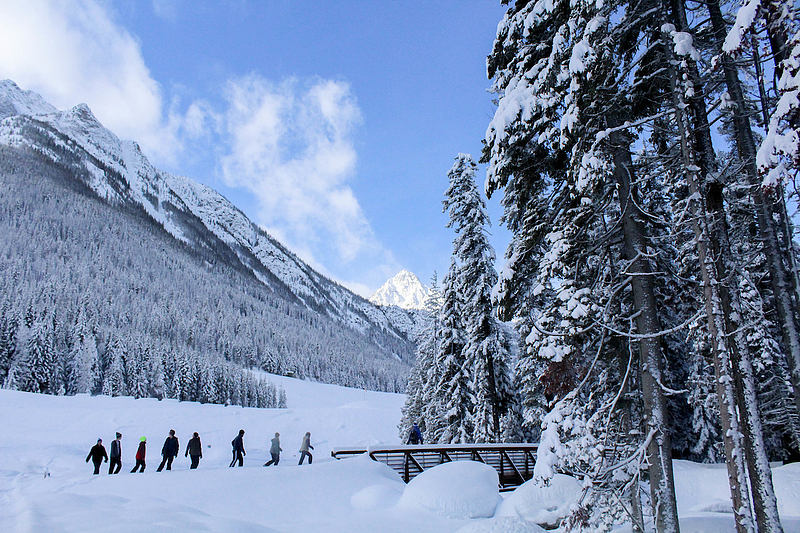 students walk in a snow-filled Cascade Mountain range located in Holden Village, WA