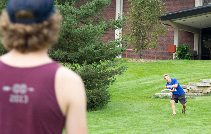 students throw a frisbee on Preus Library Lawn to stay active