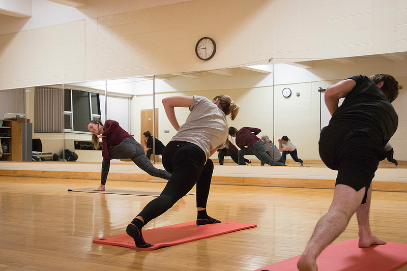 students actively doing yoga during yoga class